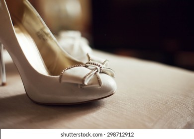 Cute stylish beige high heels with a bow on the background room, glamor, fashion, wedding