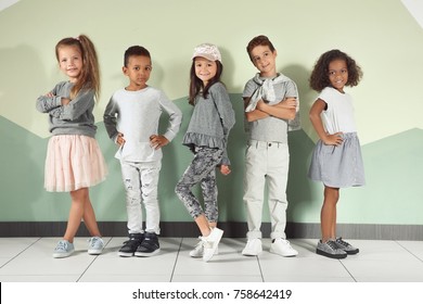 Cute stylish children near color wall