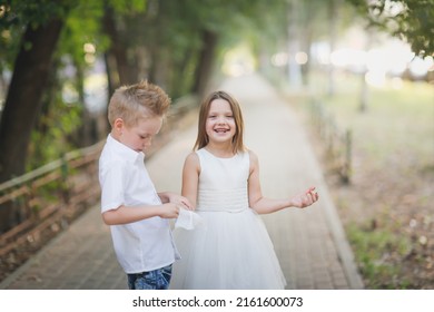 Cute Stylish European Boy Napkin Helps To Wipe The Mouth And Dirty Hands Of Girl Kid, Taking Care Of Friend, Sister.