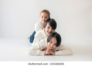 Cute Stylish Toddler Child And Older Brothers, Boys With White Shirts On White Background, Family Kids Portrait, Studio Shot