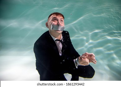 Cute Successful Young Businessman With His Mouth Taped и And Hands Tied Underwater. Drowning Competitors In Pond. Concept Of Business Competition, Rivalry, And Unwanted Partnerships. Copy Space