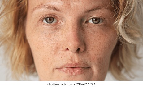 Cute sun kissed 30s woman look camera. Freckled girl face portrait. Irish young adult person. One 40s years old lady head shot. German skin care cream. Serious blond hair style. No make up life close. - Powered by Shutterstock