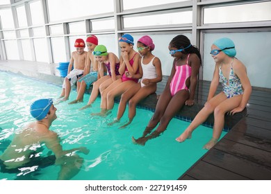 Cute swimming class in pool with coach at the leisure center - Powered by Shutterstock