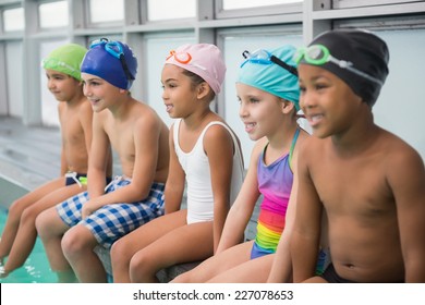 Cute swimming class smiling poolside at the leisure center - Powered by Shutterstock