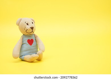 Cute Teddy Bear In Blue Stripes Side View On Yellow Background