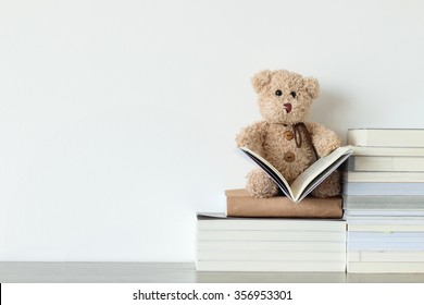 Cute teddy bear with a book that is he is reading 