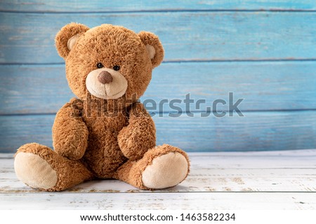 Cute teddy bear with copy space on blue color wood background.