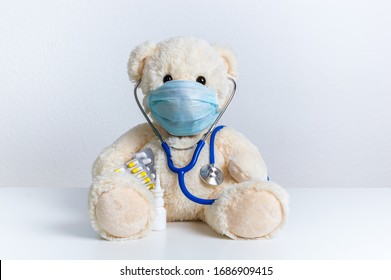 Cute teddy bear doctor with protective medical mask, stethoscope and medicine. Concept of pediatric treatment, hygiene, epidemic and virus protection for child patient. Fluffy toy on white background