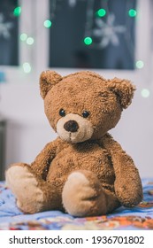 Cute teddy bear sitting on the bed