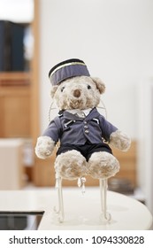 Cute teddy bear. A cute teddy bear wearing a bell boy uniform sitting on a chair in hotel lobby, with soft focus on the bear's nose.