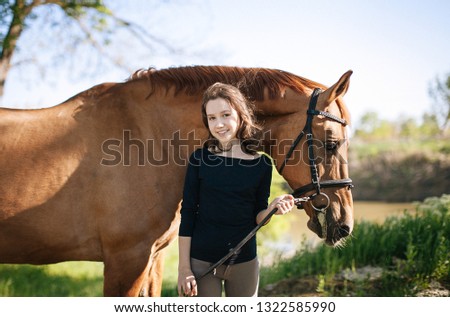 Cute teen girl near  a red horse for a walk, photo to the world women's day