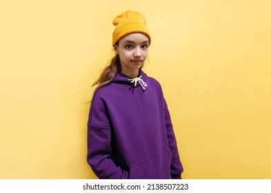 Cute Teen Girl In A Purple Hoodie. Kids Hoodies Mockup. Studio Shot On Yellow Background.