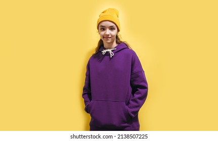 Cute Teen Girl In A Purple Hoodie. Kids Hoodies Mockup. Studio Shot On Yellow Background.