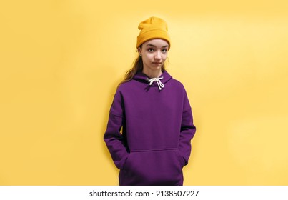 Cute Teen Girl In A Purple Hoodie. Kids Hoodies Mockup. Studio Shot On Yellow Background.