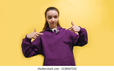 Cute Teen Girl In A Purple Hoodie. Kids Hoodies Mockup. Studio Shot On Yellow Background.