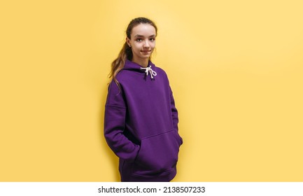 Cute Teen Girl In A Purple Hoodie. Kids Hoodies Mockup. Studio Shot On Yellow Background.