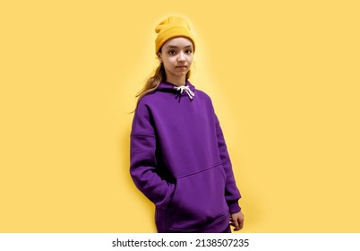 Cute Teen Girl In A Purple Hoodie. Kids Hoodies Mockup. Studio Shot On Yellow Background.