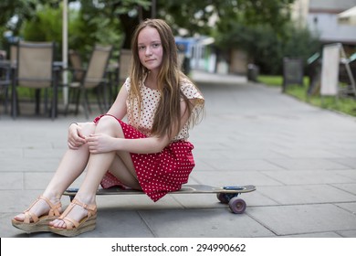 Cute Teen Girl Sitting On A Skateboard On The Street Cute Teen Girl Sitting On A Skateboard On The Street