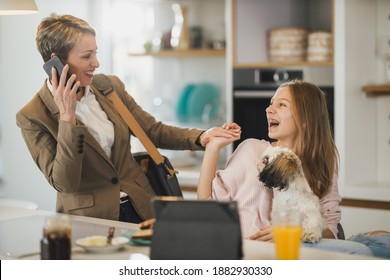 Cute Teenage Girl And Her Smiling Mother Is Greet Each Other At Her Home While Mom Getting Ready To Go To Work.