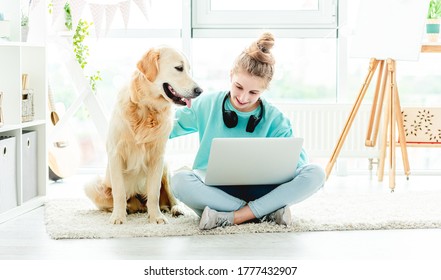 Cute Teenage Girl With Laptop And Beautiful Dog Sitting On Floor Indoors