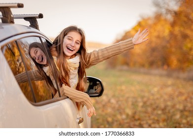 Cute Teenage Girl Peeking Out Car Window On Autumn Background