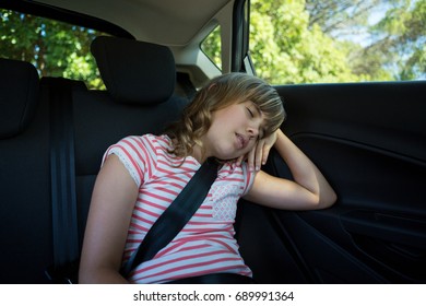 Cute teenage girl sleeping in the back seat of car - Powered by Shutterstock