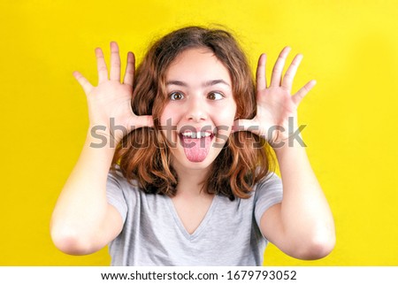 Cute teenager girl with funny face smiling with big eyes to the camera