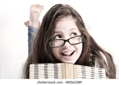 Cute Teenager Girl Laying On The Floor And Reading A Book At Home