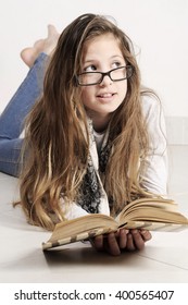 Cute Teenager Girl Laying On The Floor And Reading A Book At Home