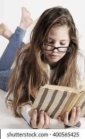 Cute Teenager Girl Laying On The Floor And Reading A Book At Home