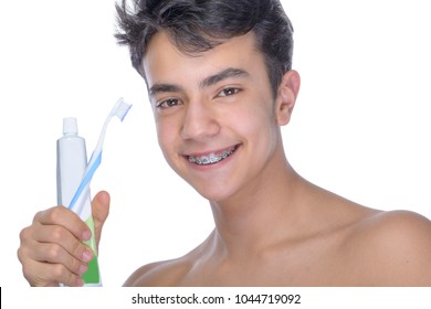 Cute teenager with white background, wearing braces on his teeth. Use toothbrush and toothbrush for cleaning.