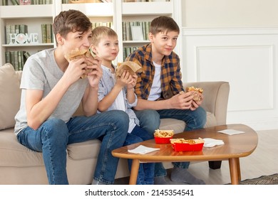 A Cute Three Teenage Boys, Eating Fast Food In Living Room, Watch Tv