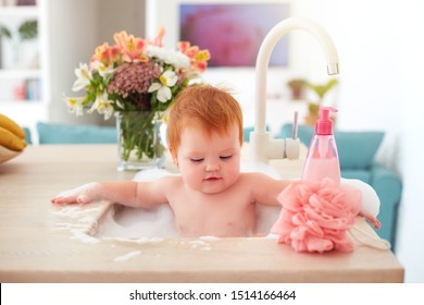 Cute Tiny Baby Girl Taking A Bubble Bath In A Kitchen Sink