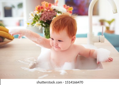 Cute Tiny Baby Girl Taking A Bubble Bath In A Kitchen Sink