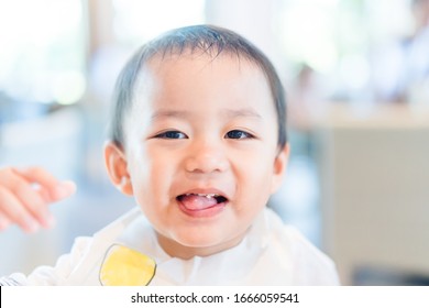 Cute Toddler Asian Boy In A Chair Talking And Asking Father For Hard Question.Adorable Baby Learning To Speak.Asian Baby Boy Try To Talk In Table Kitchen.child With No Appetite In Front Of The Meal.