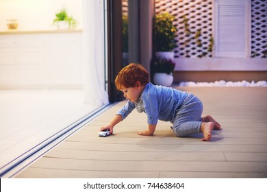 cute toddler baby boy playing with toy car at the patio with open space kitchen and sliding doors