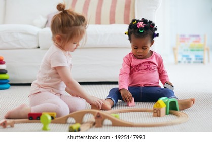 Cute Toddler Baby Girls Playing Toys Together On The Carpet