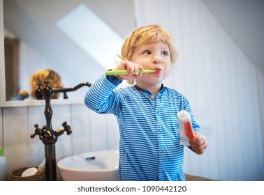 Cute Toddler Boy Brushing His Teeth In The Bathroom.