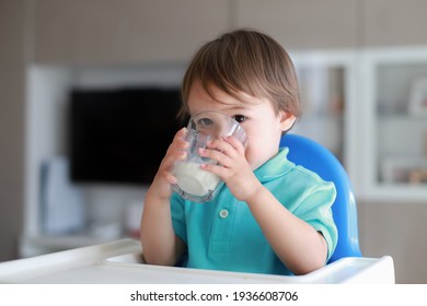 Cute Toddler Boy Drinking Milk From Glass On High Chair.Mixed Race Asian-German Baby With Healthy Nutrition.Little Child About 1-2 Years Old.