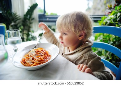 Cute Toddler Boy Eating Pasta In Italian Indoors Restaurant. Healthy/unhealthy Food For Little Kids