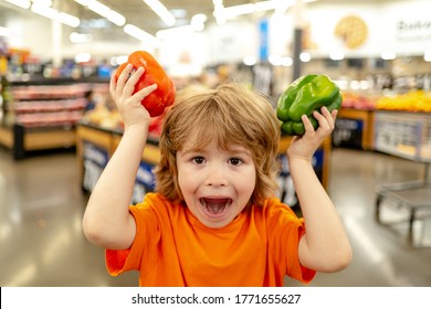 Cute toddler boy in a food store or a supermarket choosing fresh organic carrots. Healthy lifestyle for young family with kids.