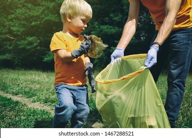 Cute toddler boy and his father collecting garbage in the park. Volunteers family picking up litter in the forest. Environmental protection concept. - Powered by Shutterstock