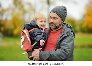 Cute Toddler Boy In His Fathers Arms. Dad And Son Having Fun On Sunny Autumn Day. Adorable Son Being Held By His Daddy. Active Family Time At Fall Season.