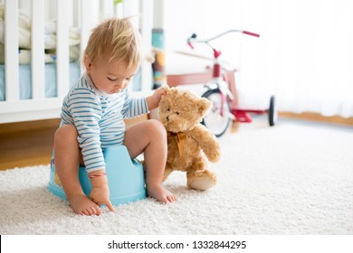 Niño pequeño, entrenamiento de caca, jugando con su oso de peluche en caca