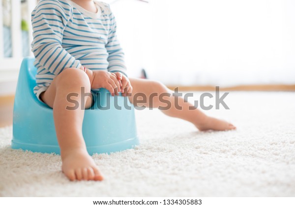 A Little Baby Girl Is Sitting On A Potty. Potty Training