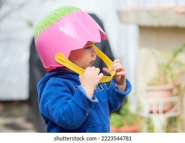 Cute Toddler Boy Pretending To Be A Football Player With An Easter Basket For A Helmet