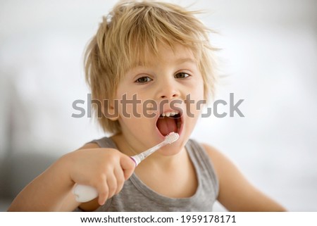 Similar – Happy adorable infant baby boy child smiling while eating two frozen fruit popsicle ice creams in simmer.