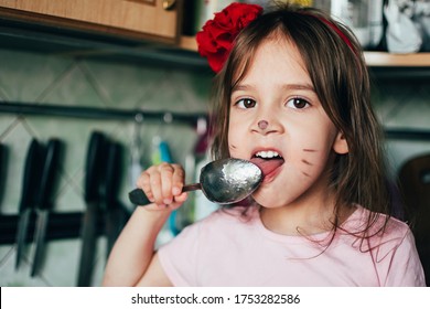 Cute  Toddler Girl With Face Painting Like A Cat, Licking Spoon With Honey In The Kitchen. Real Life Moments.  Fun In The Kitchen With  Little Helper.