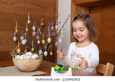 Cute Toddler Girl Having Fun Whilst Paining Easter Eggs  The Emotion Of Excitement About The Mixture Of Colors With An Unexpected Outcome