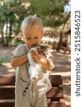 Cute toddler girl playing with kittens in public park